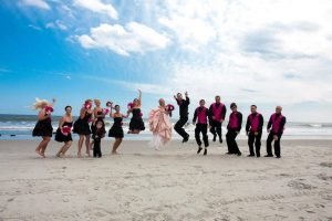 wedding party jumping on the beach