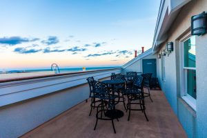 Balcony seating area with tables and chairs. View of the sky