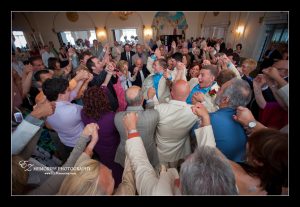 wedding guests dancing and singing in crystal ballroom