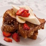 French toast topped with strawberries and bananas