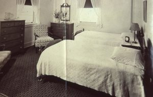 Vintage black and white photo of suite with two beds