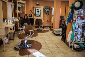 Divine Images salon worker cutting guest's hair