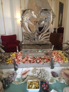 Dolphin ice sculpture surrounded by cold shellfish spread