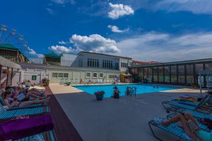 Poolside photo of swimmers and people lounging