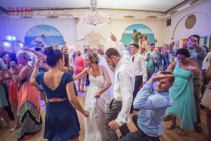 Wedding guests dancing with bride and groom in Crystal ballroom