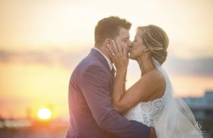 Bride and groom kissing in the sunset