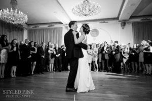 black and white photo of bride and groom dancing