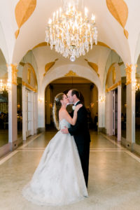 bride and groom kissing in the hall of mirrors